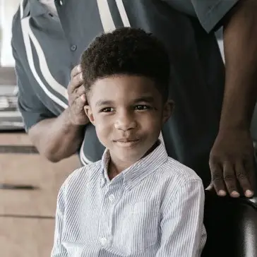 young boy sitting in barbers chair